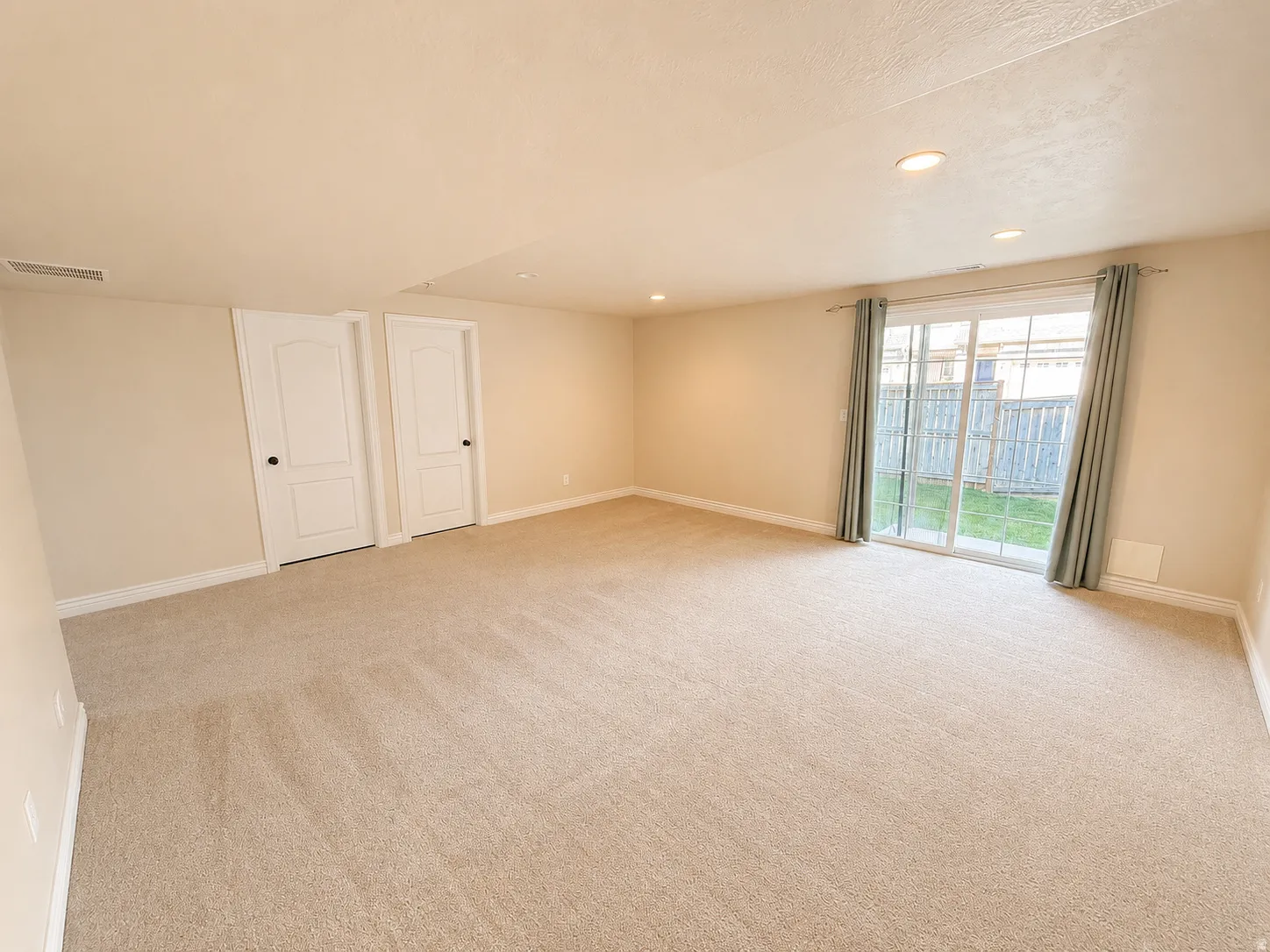 Expansive carpeted room featuring recessed lighting, light-toned walls, and white baseboards