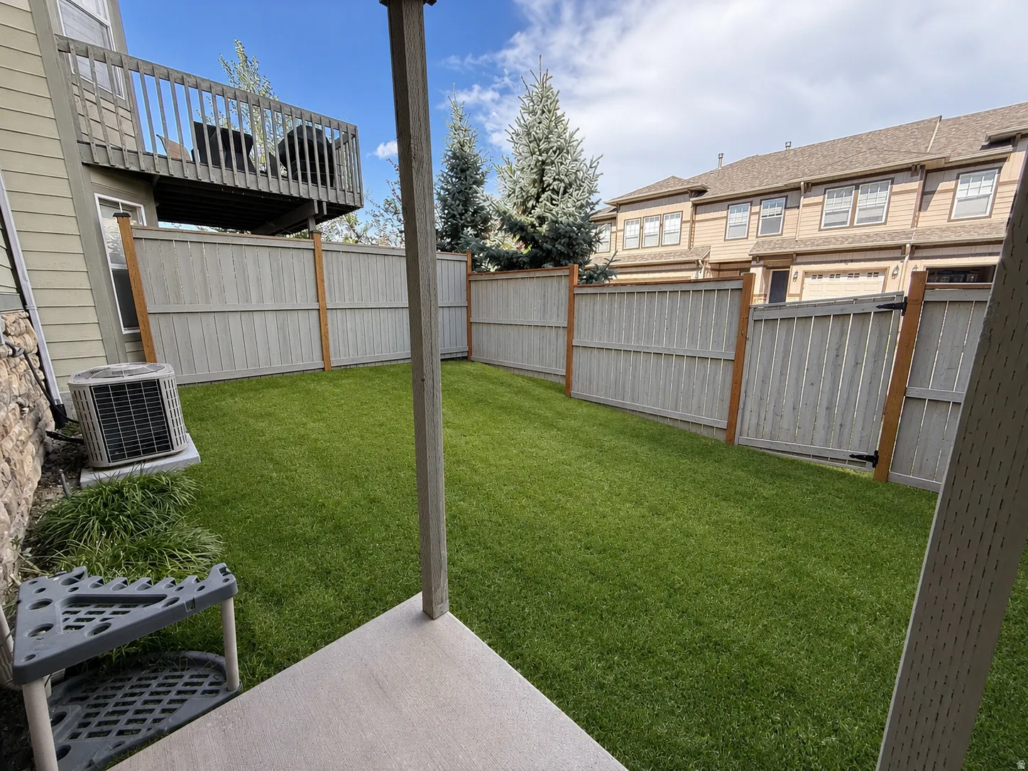Enclosed backyard featuring a manicured lawn, full privacy fencing, and a ground-level patio