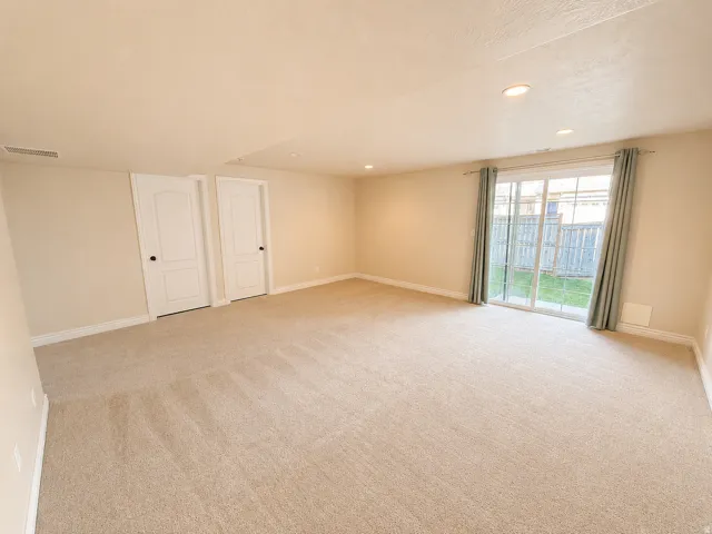 Expansive carpeted room featuring recessed lighting, light-toned walls, and white baseboards