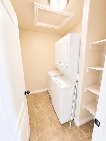 Dedicated laundry area featuring neutral-toned floor tile and light-colored walls