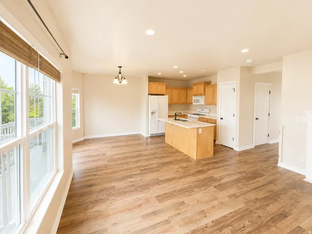 Open-concept living space featuring wood-finish flooring, recessed lighting, and a kitchen island with a light-colored countertop