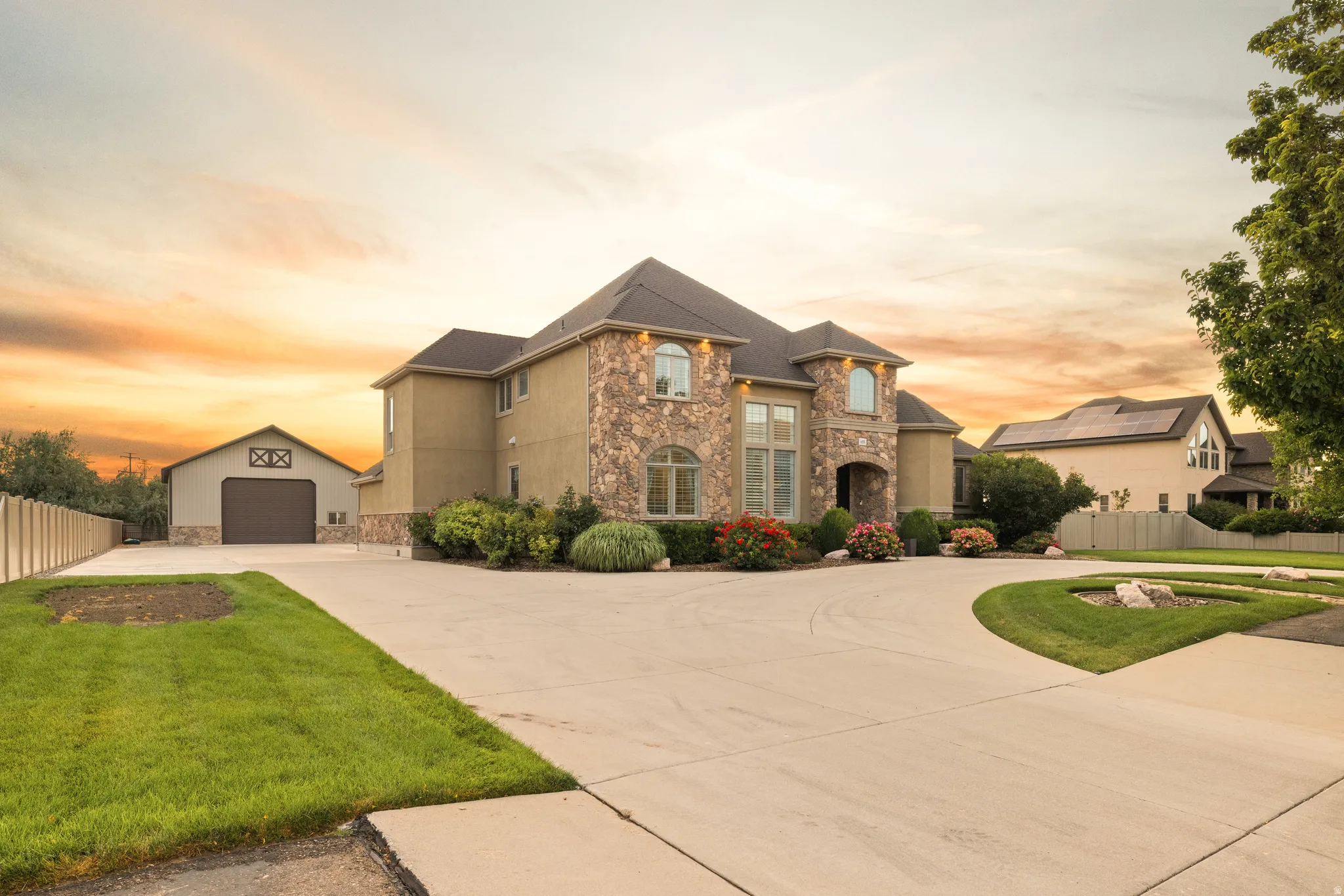 Stately residence featuring a stone and stucco exterior, arched windows, and a multi-level roofline