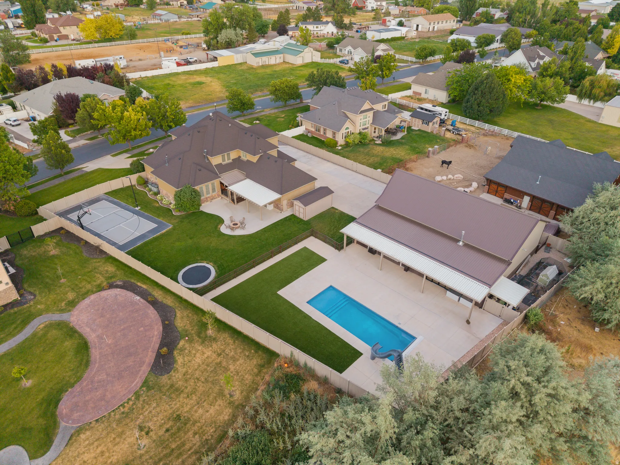 Expansive property featuring a large residence, a separate barn-style structure, and varied outdoor amenities