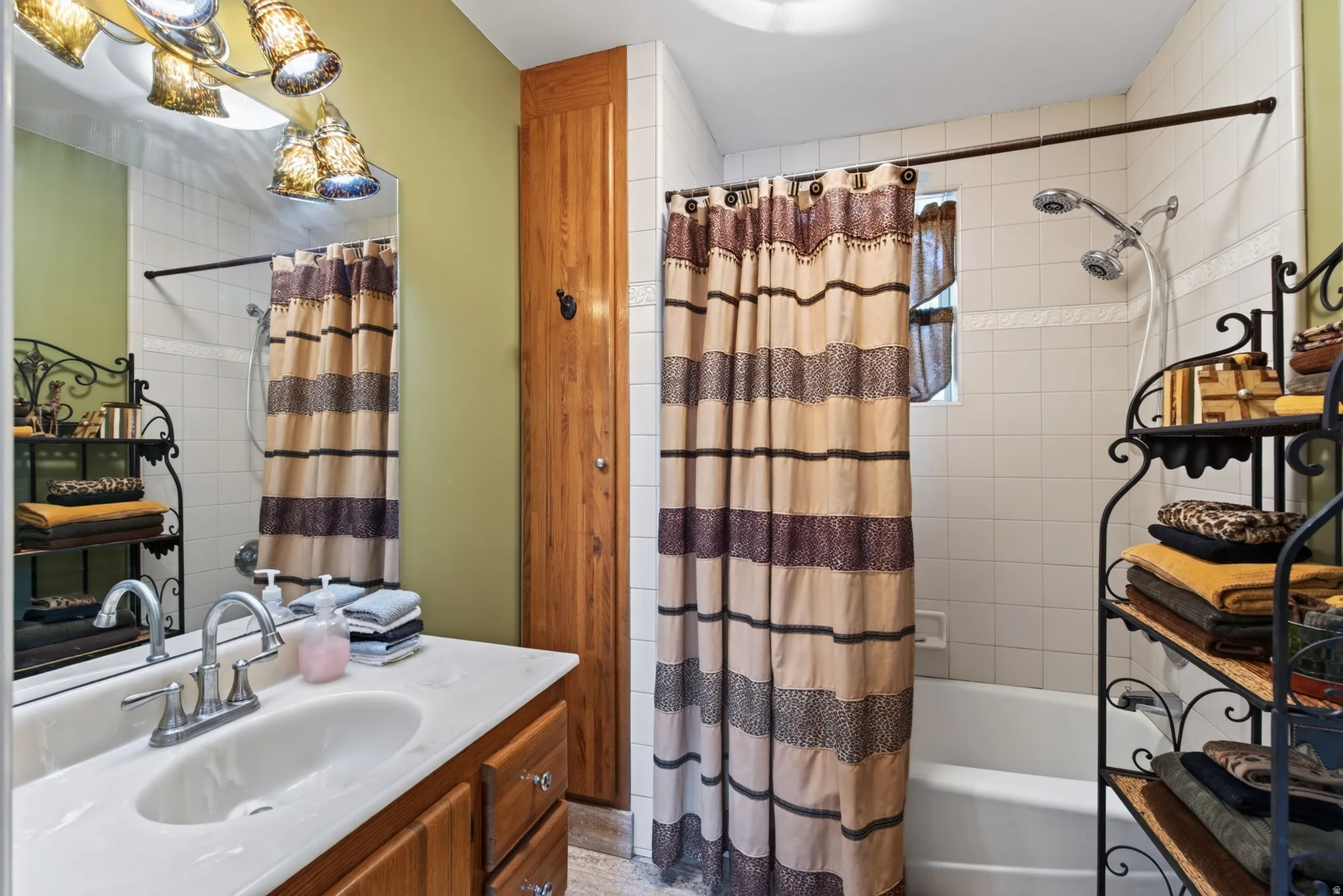 Bathroom featuring a single vanity with a white countertop, chrome faucet, and wood-finish cabinetry