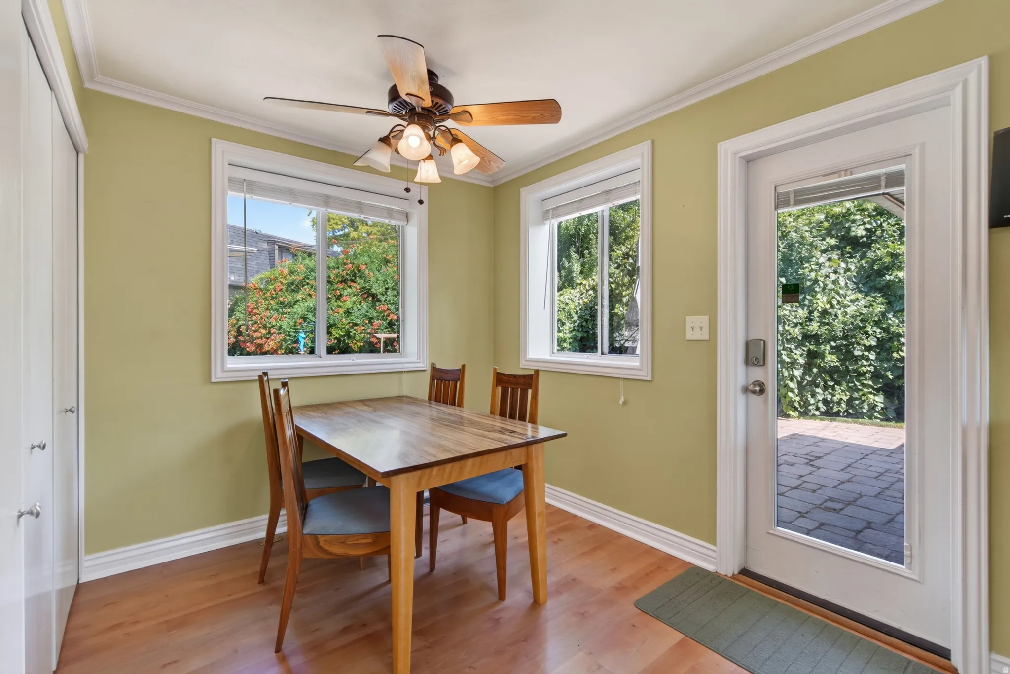 Dining area with wood-finish flooring, two windows, and crown molding