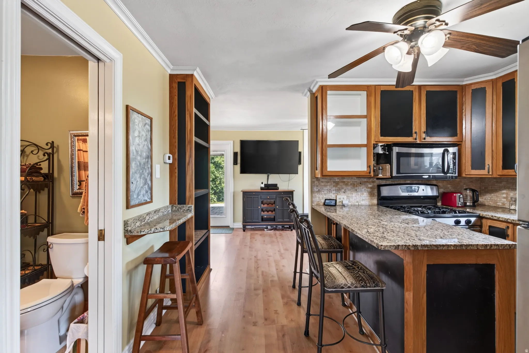 Kitchen featuring a gas range, microwave, and wood-finish cabinetry