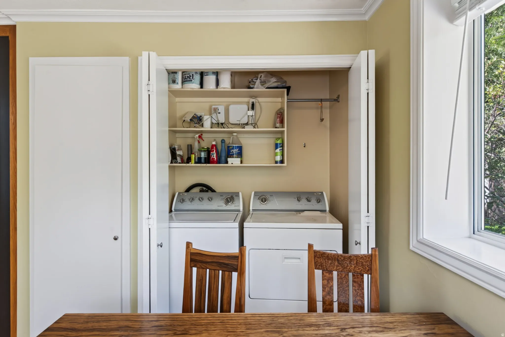 Dedicated laundry area featuring built-in shelving, a hanging rod, and appliances