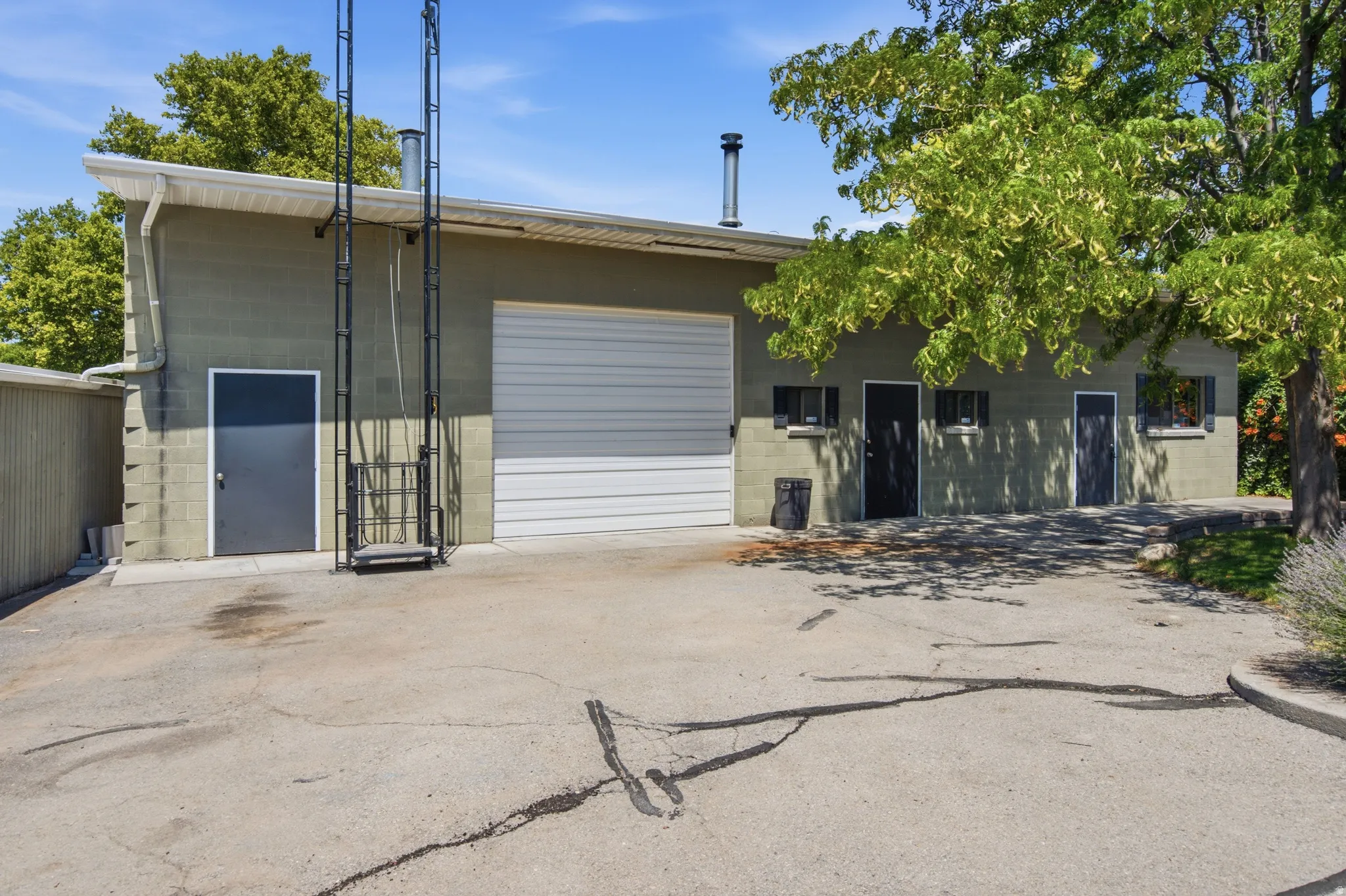 Commercial building with painted block exterior, featuring a large white roll-up door and multiple access doors