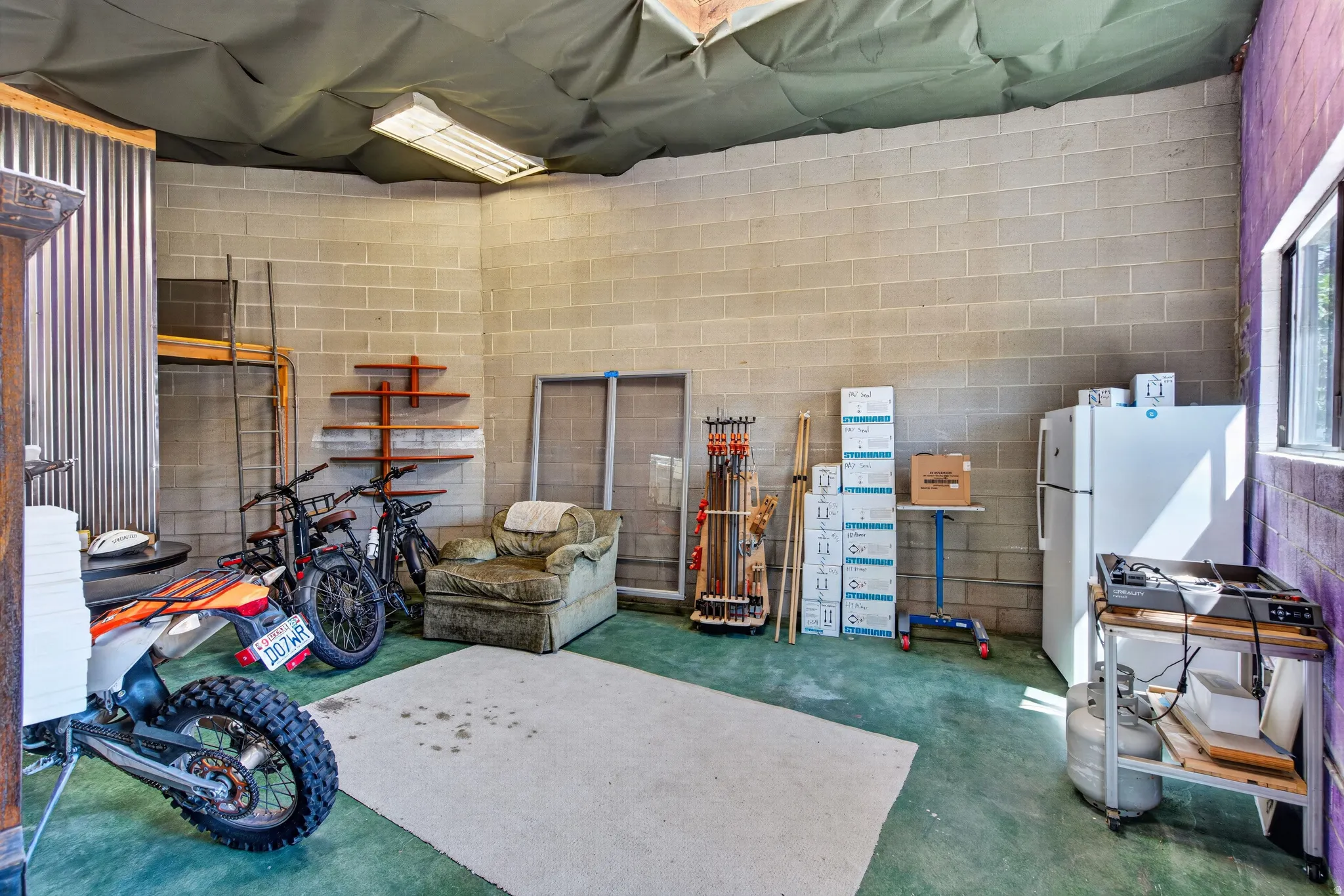 Utility space featuring block walls and a corrugated metal accent wall