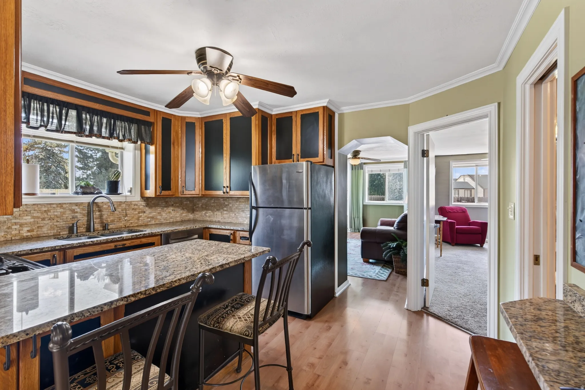 Kitchen featuring wood-finish flooring, stainless steel appliances, and a central island with a granite countertop