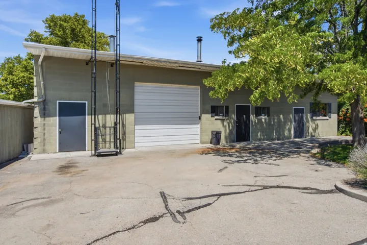 Commercial building with painted block exterior, featuring a large white roll-up door and multiple access doors