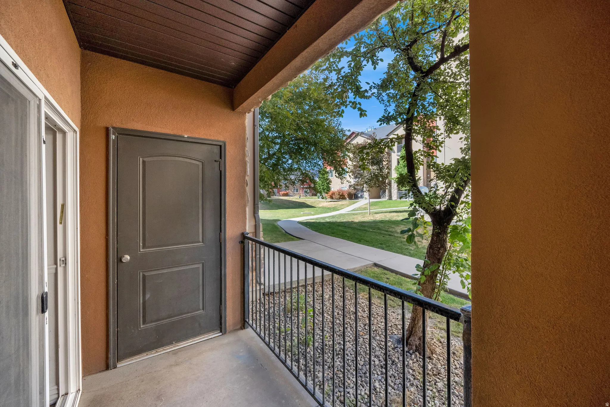 Private balcony with textured stucco walls and dark-paneled ceiling