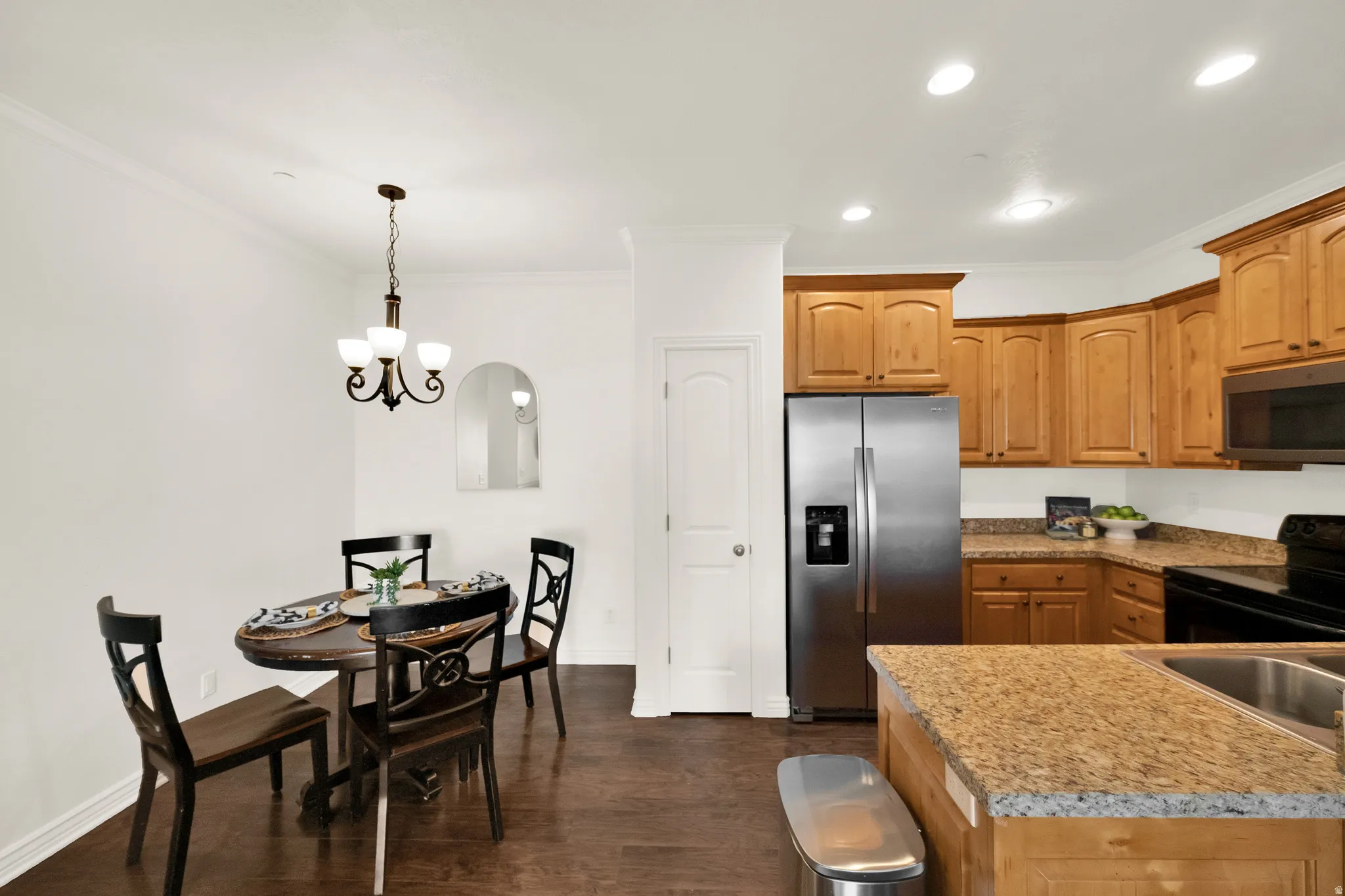 Kitchen featuring wood-finish cabinetry, granite-style countertops, and stainless steel appliances