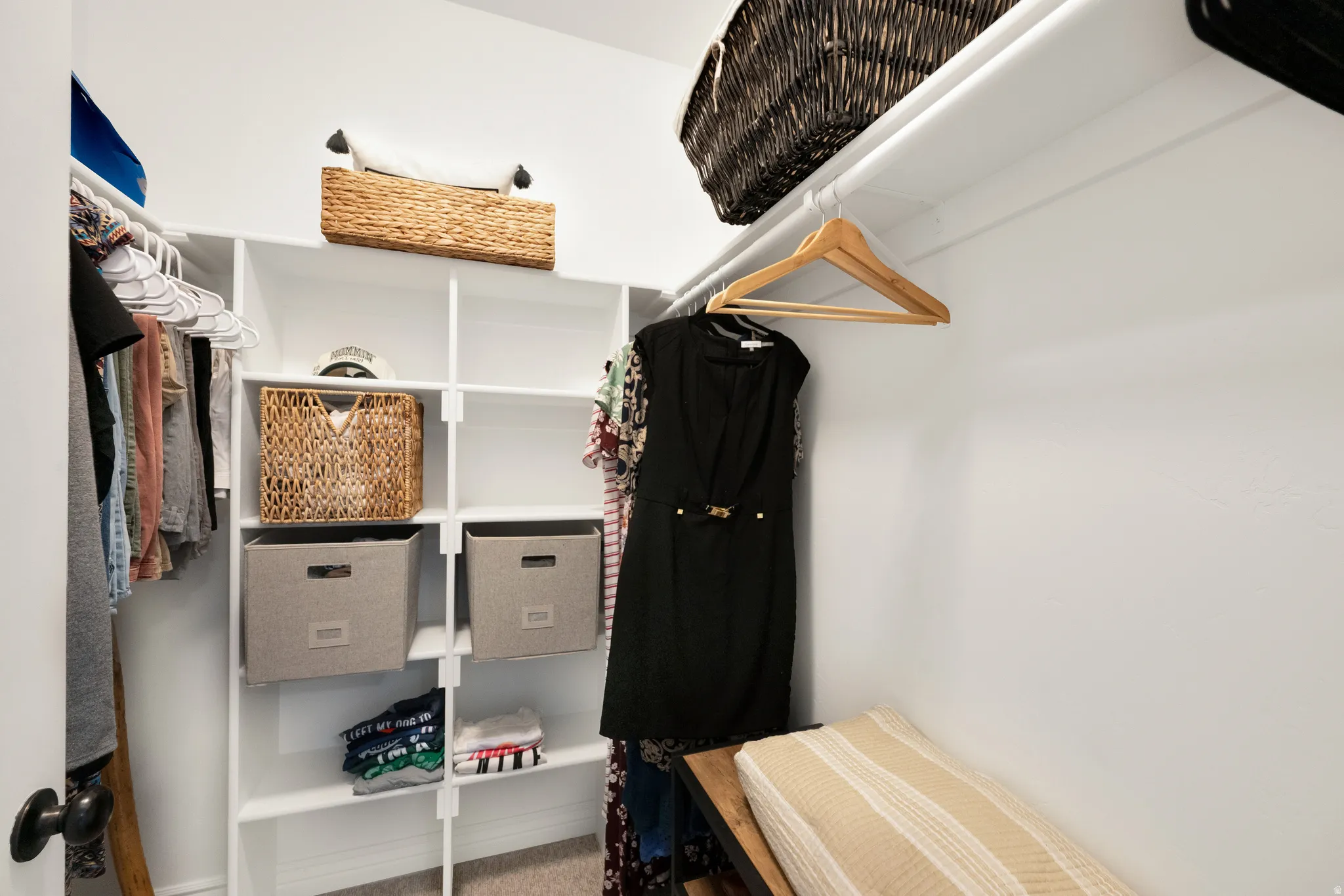 Organized closet space featuring white shelving units, multiple hanging rods, and recessed lighting
