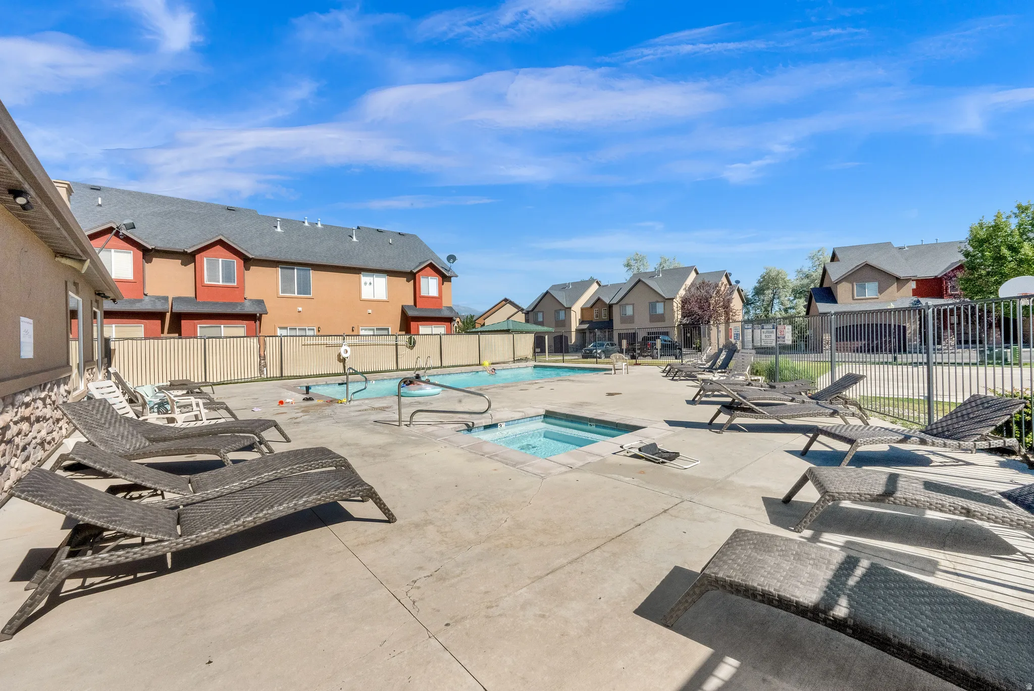 Outdoor swimming pool with integrated spa and surrounding concrete deck