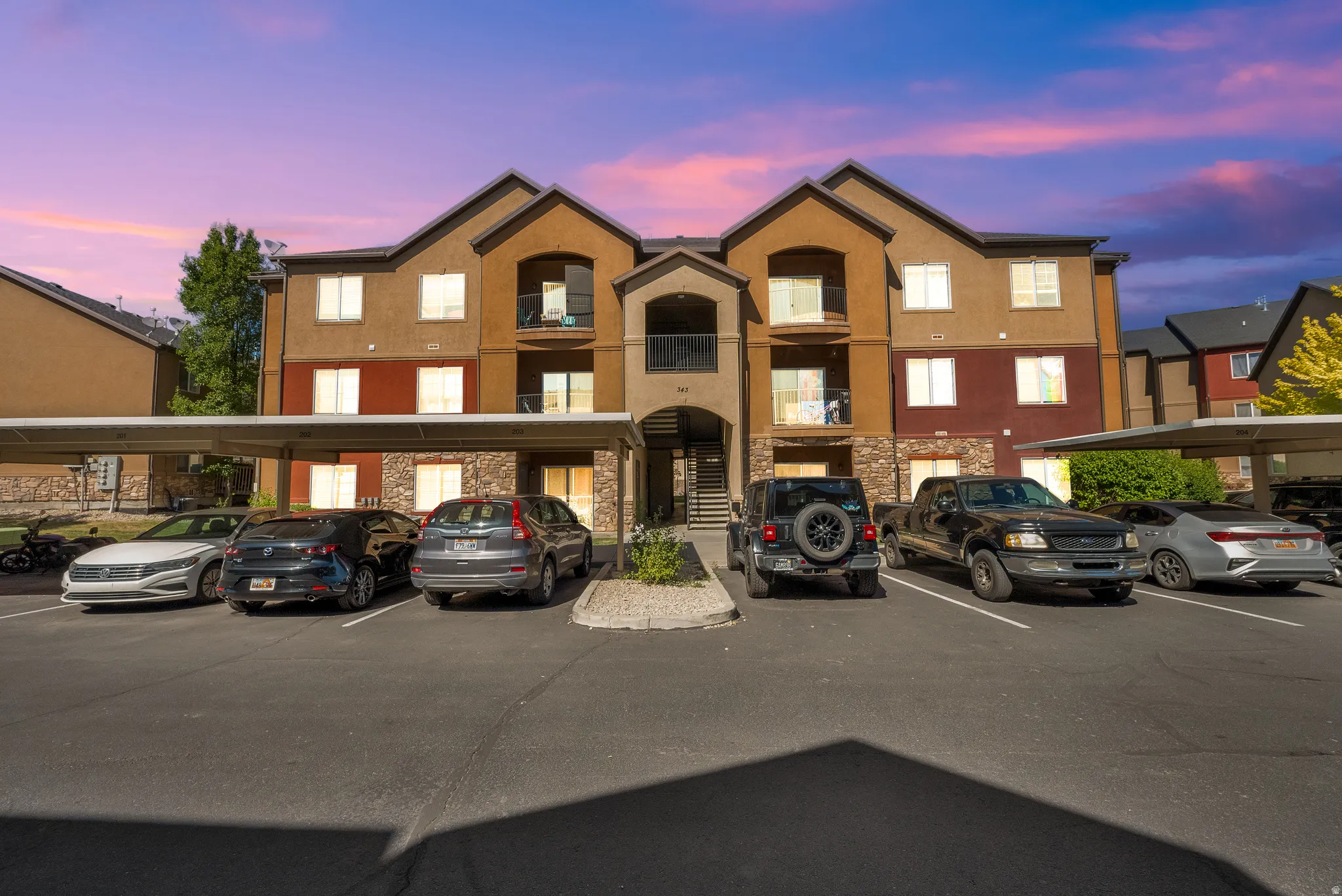Three-story multi-unit dwelling featuring a combination of stucco and stone veneer exterior finishes