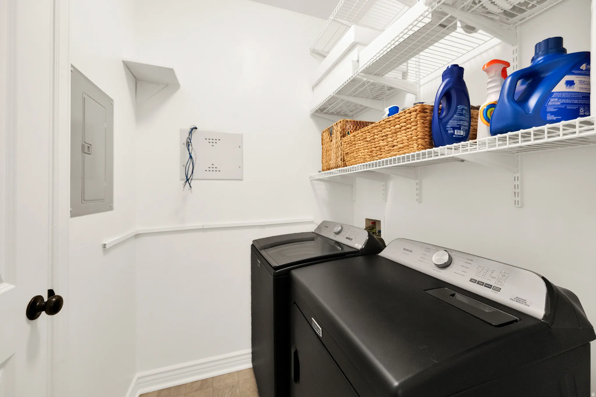 Dedicated laundry area featuring wire shelving