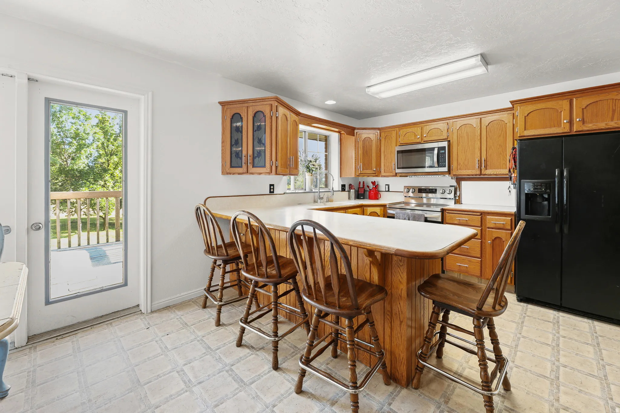 Kitchen featuring wood cabinetry, white countertops, and a black refrigerator