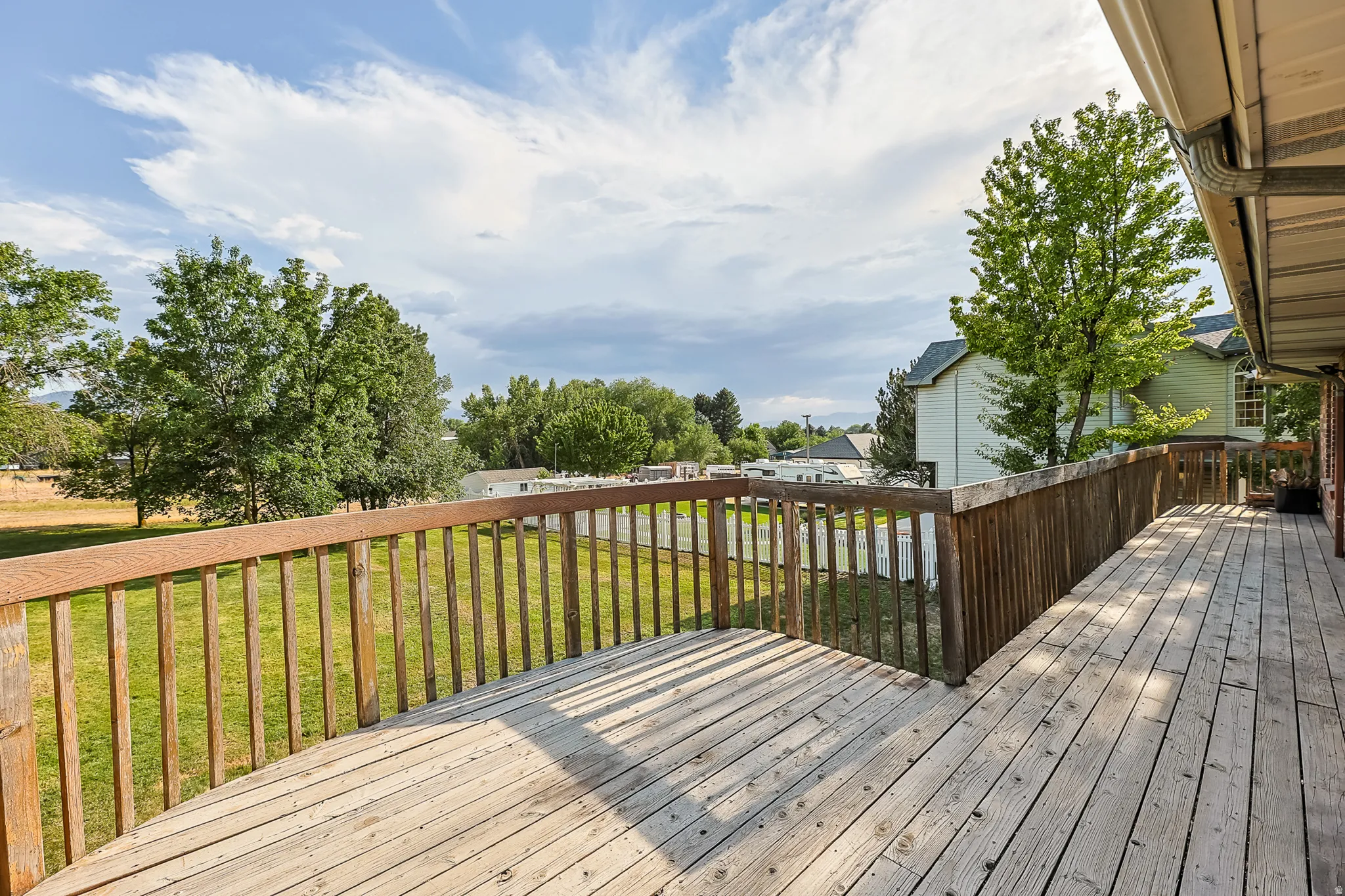 Expansive outdoor deck with natural wood flooring and coordinating wood railing