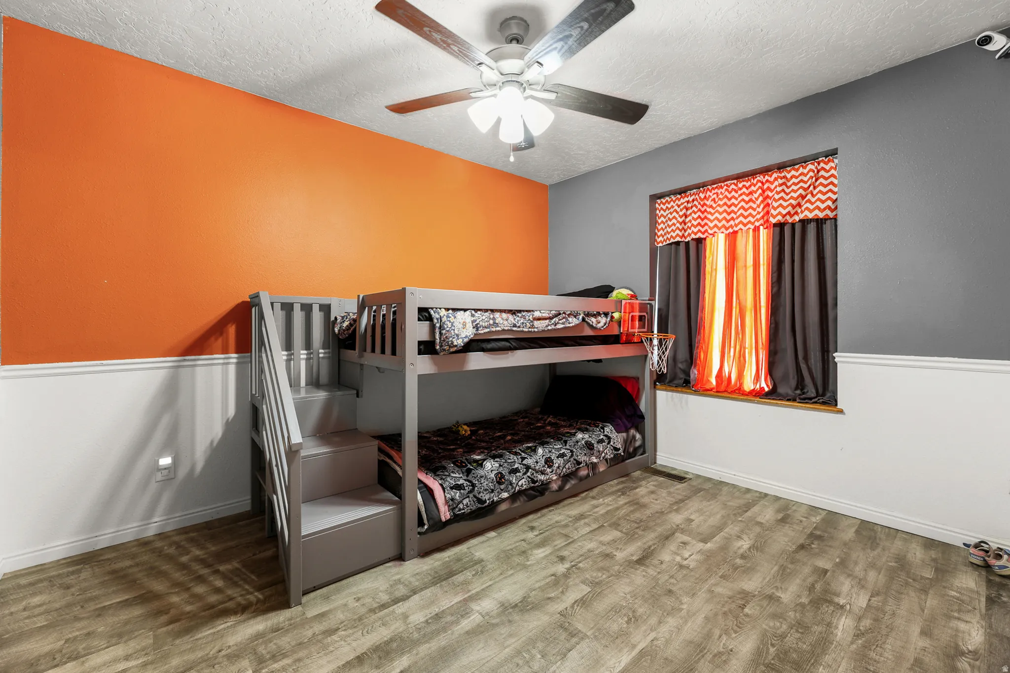 Room featuring wood-finish flooring, a contemporary ceiling fan with light, and a window opening