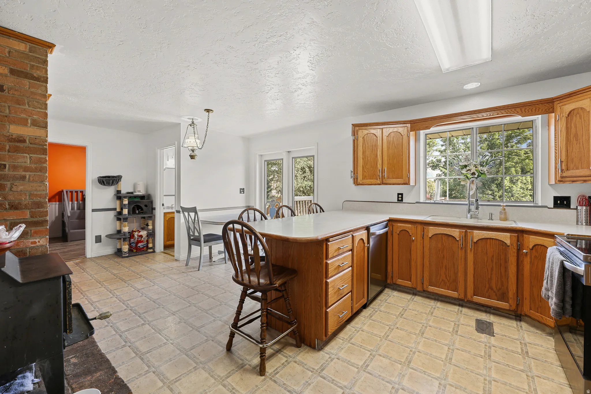 Kitchen featuring wood-finish cabinetry, solid surface countertops, and a window above the sink