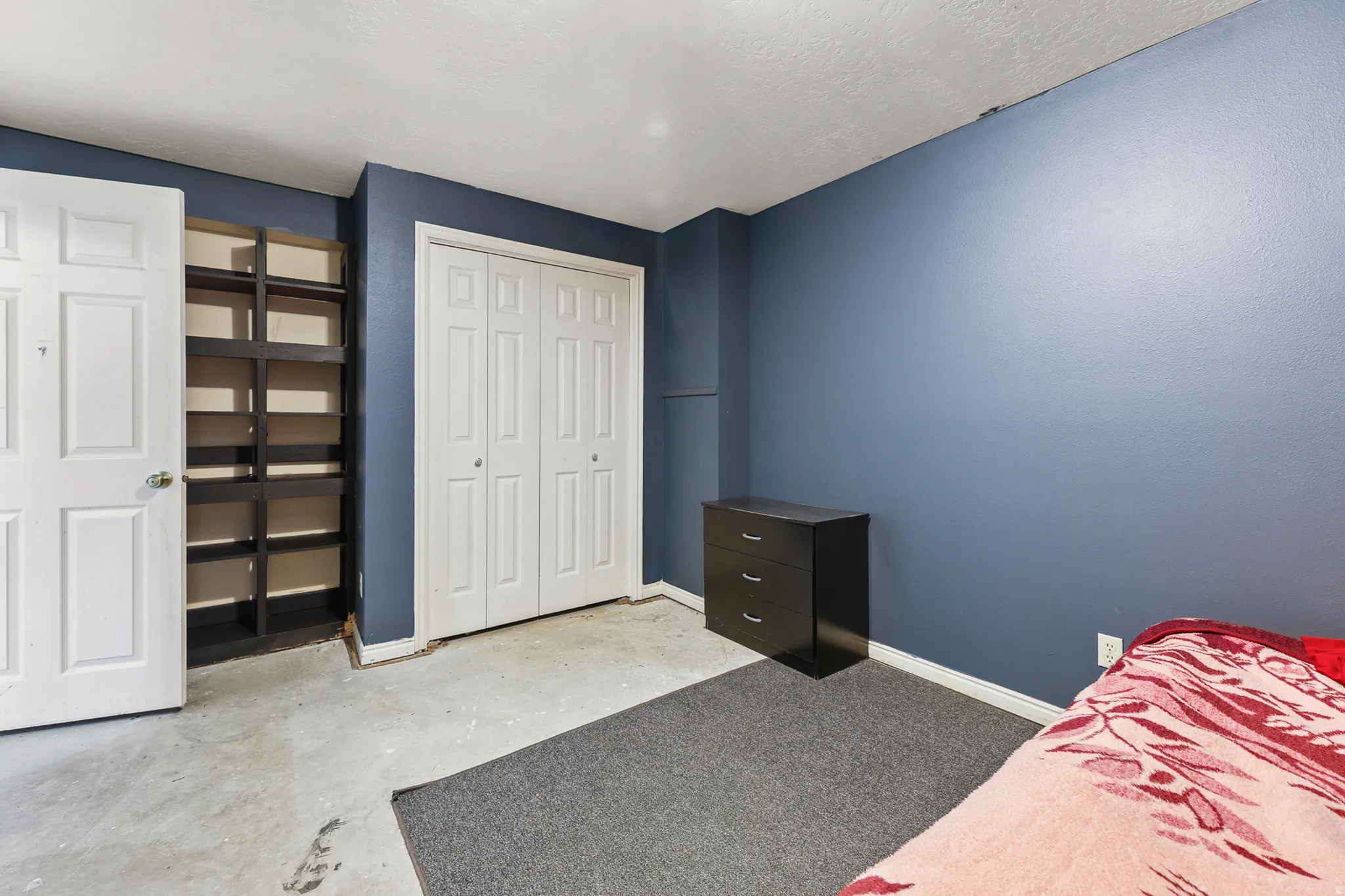 Bedroom featuring a built-in shelving unit, double bi-fold closet doors, and recessed ceiling lighting