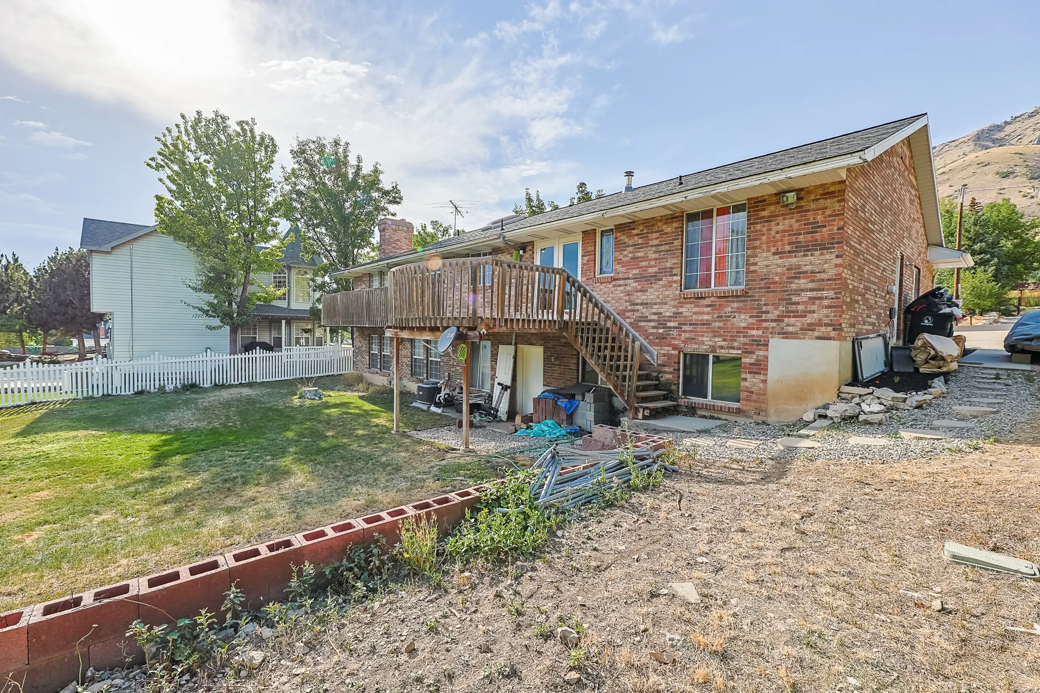 Brick exterior with a wooden deck and staircase