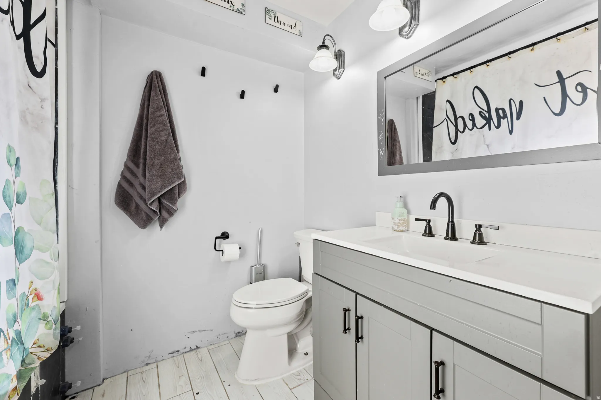 Bathroom featuring a white vanity with a light gray cabinet base, an integrated sink, and a matte black faucet