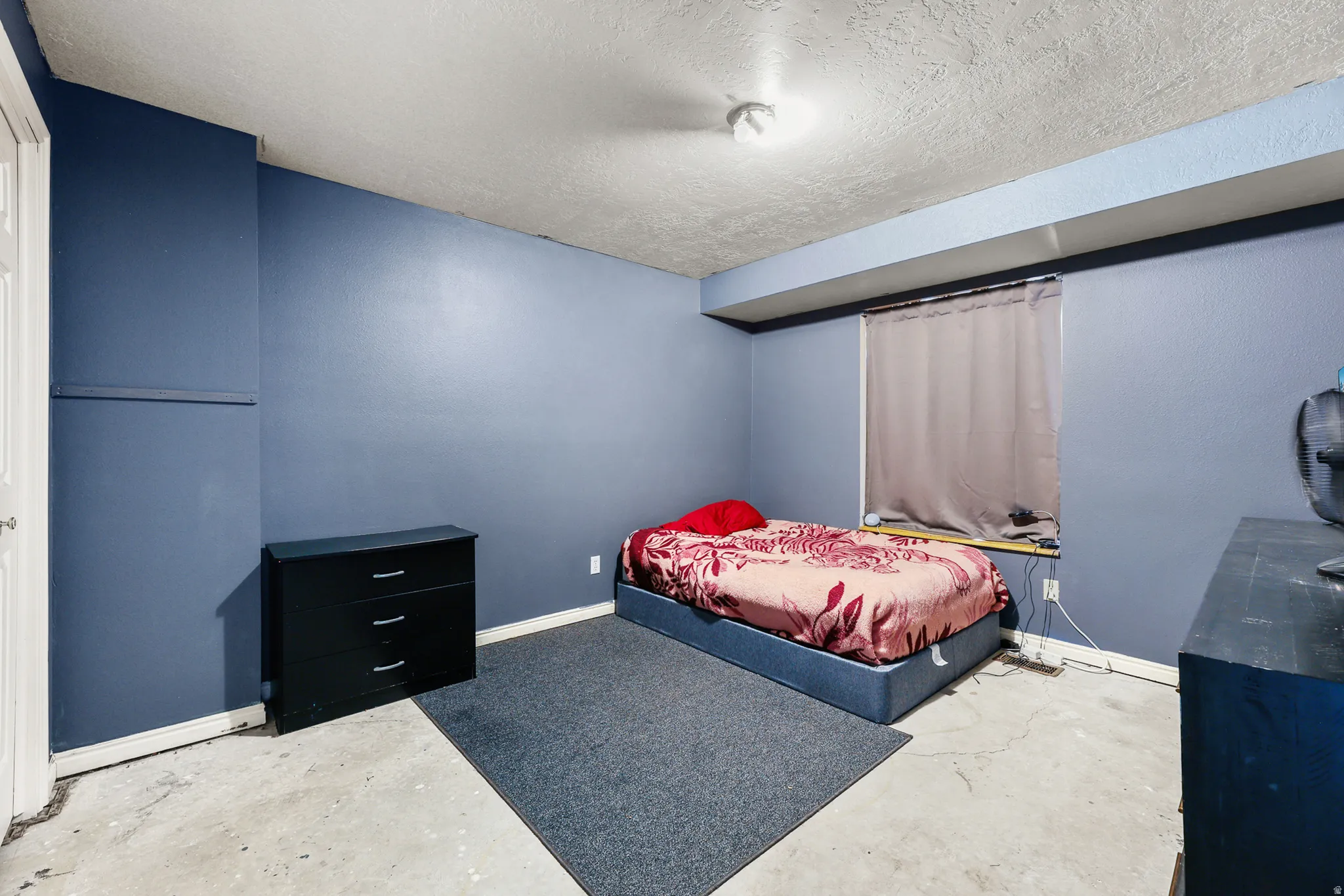 Room featuring painted blue walls and a textured ceiling