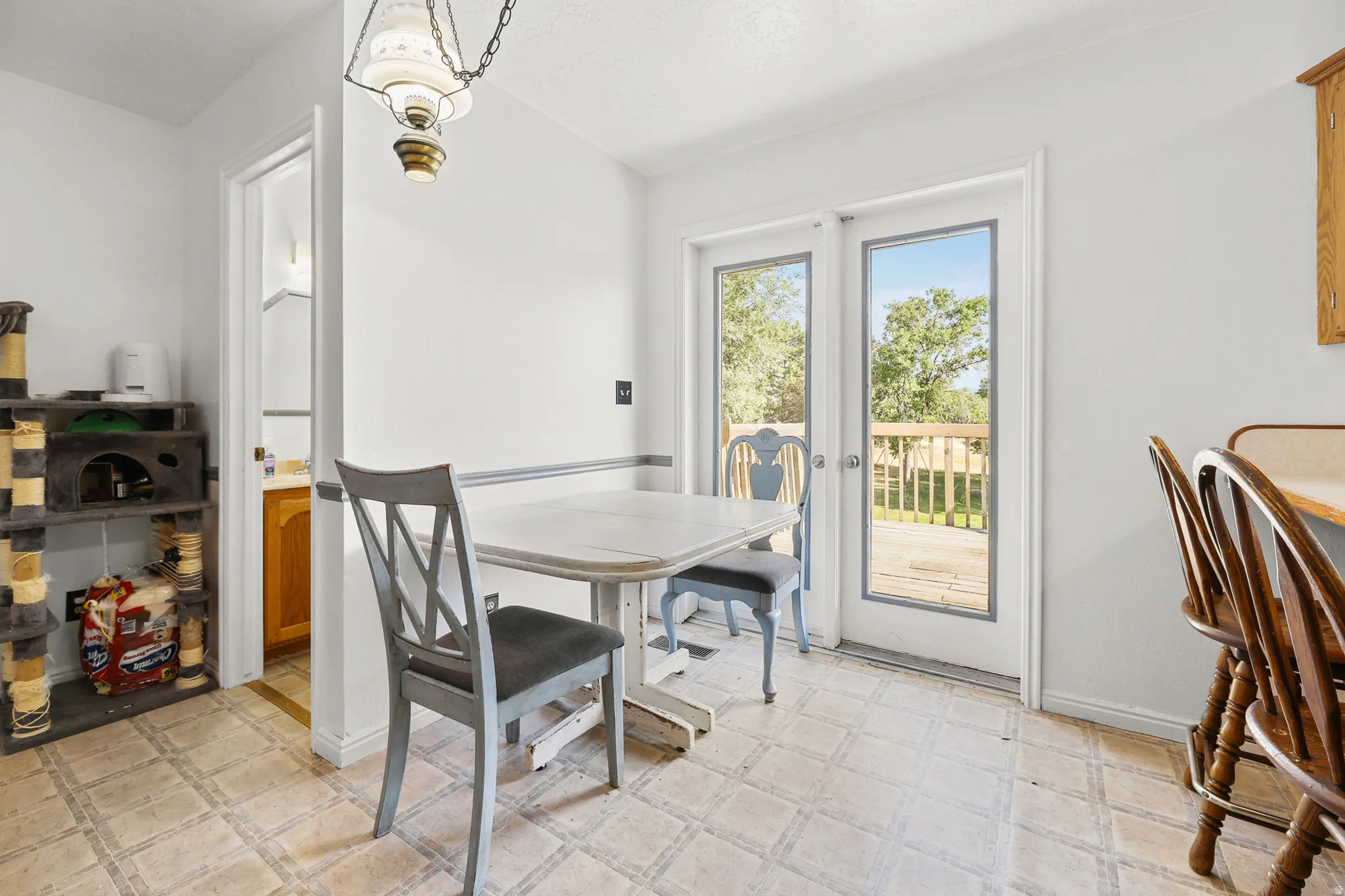 Dining area with patterned tile flooring, a brass-finished pendant light fixture, and white walls