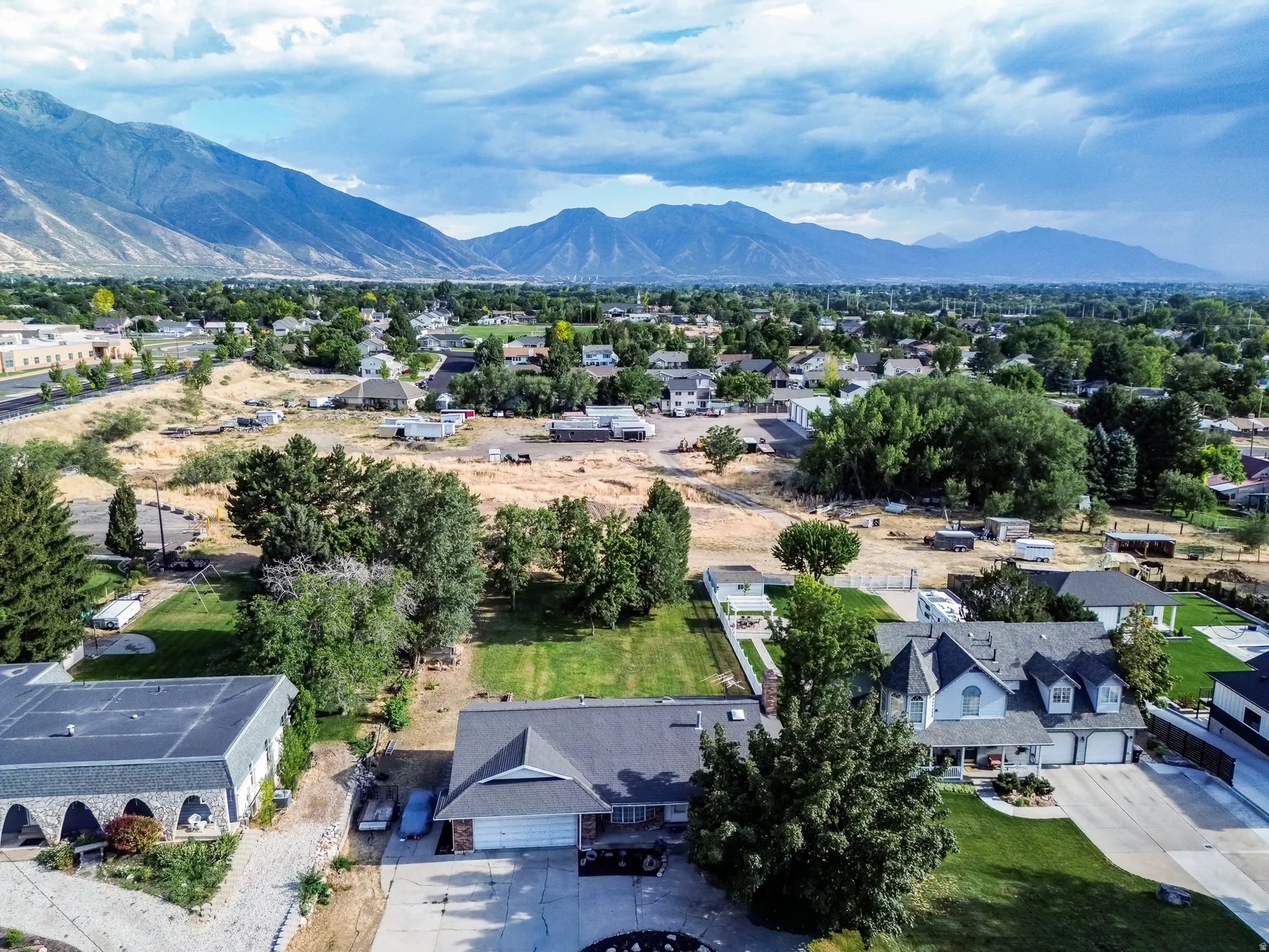 Mountain range backdrop with a residential neighborhood featuring established trees and varied property sizes
