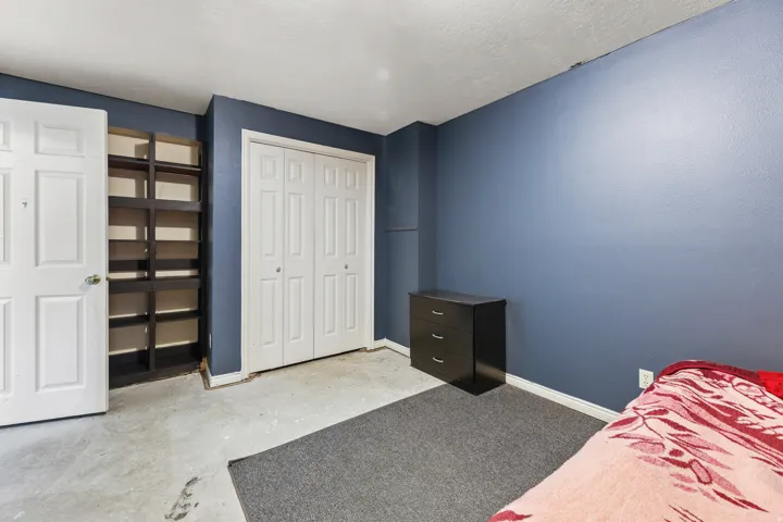 Bedroom featuring a built-in shelving unit, double bi-fold closet doors, and recessed ceiling lighting