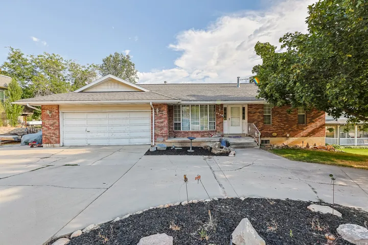 Brick facade home featuring a two-car garage, concrete driveway, and front entryway