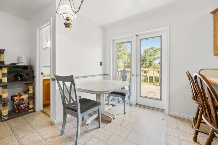 Dining area with patterned tile flooring, a brass-finished pendant light fixture, and white walls