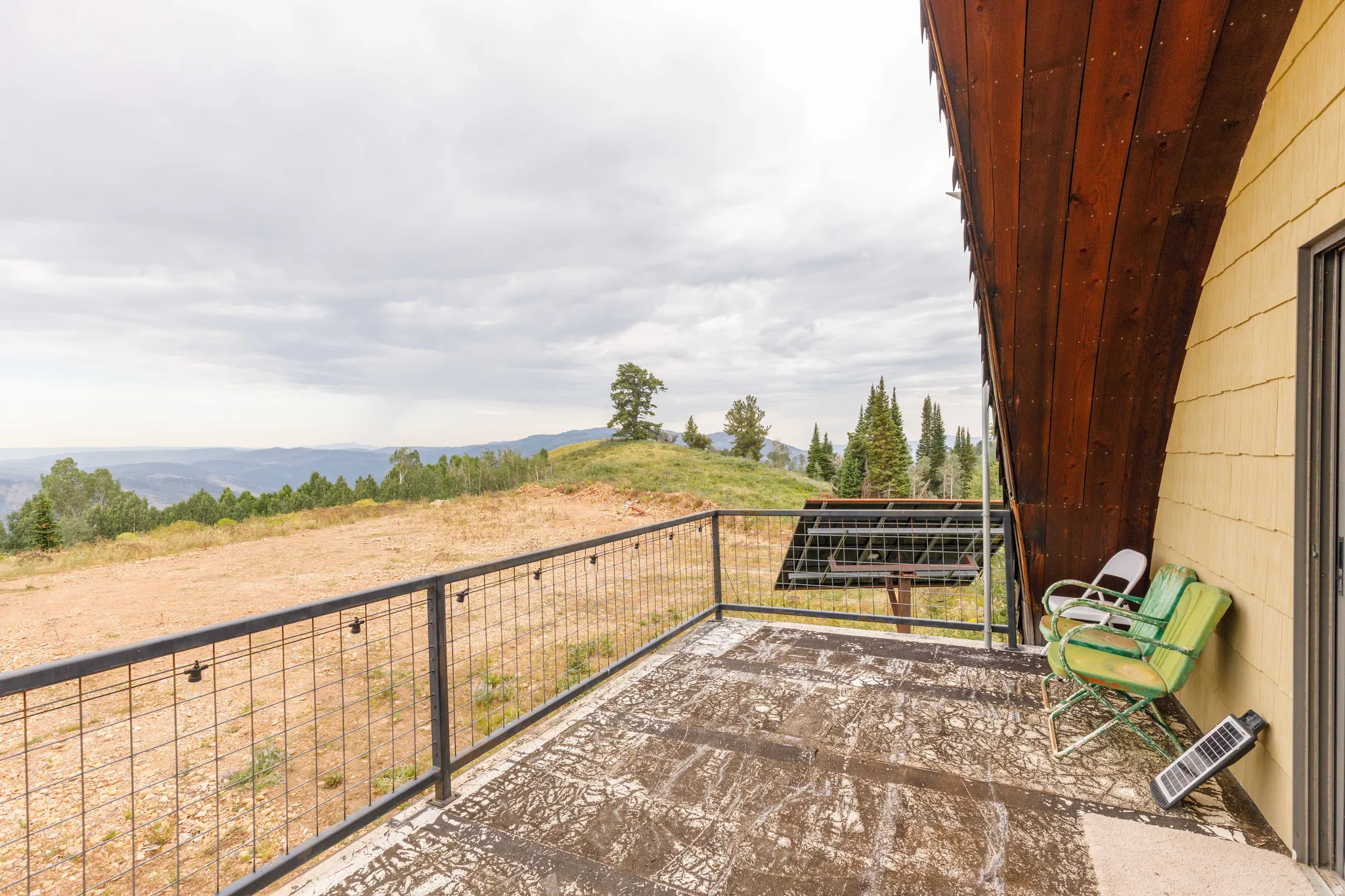 Terrace featuring a metal wire railing, a distinct curved wood-panel ceiling, and horizontal siding