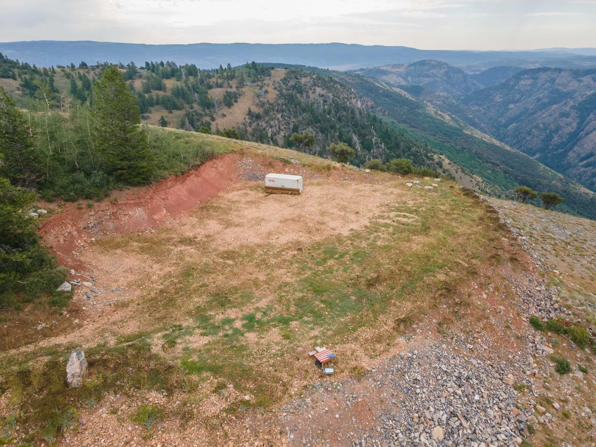 Expansive mountain terrain featuring a cleared, level building area