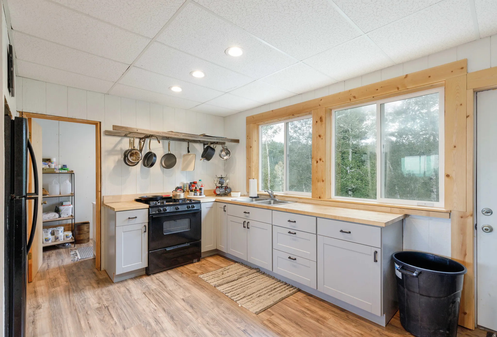 Kitchen featuring wood-finish flooring, light gray cabinetry, and butcher block countertops