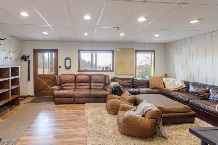 Spacious interior featuring recessed lighting, wood-finish flooring, vertical paneling, and an exterior door with glass panels