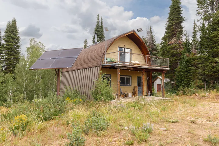 Rustic cabin-style residence featuring a prominent solar panel array