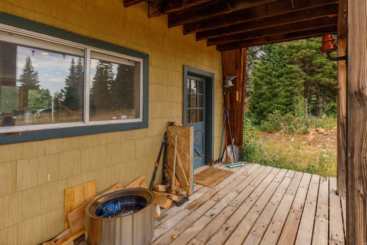 Wood-plank porch with a wood-paneled ceiling and exposed beams