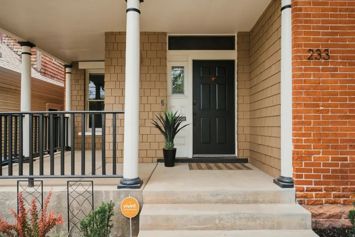 Inviting covered porch with robust white columns and a black metal railing