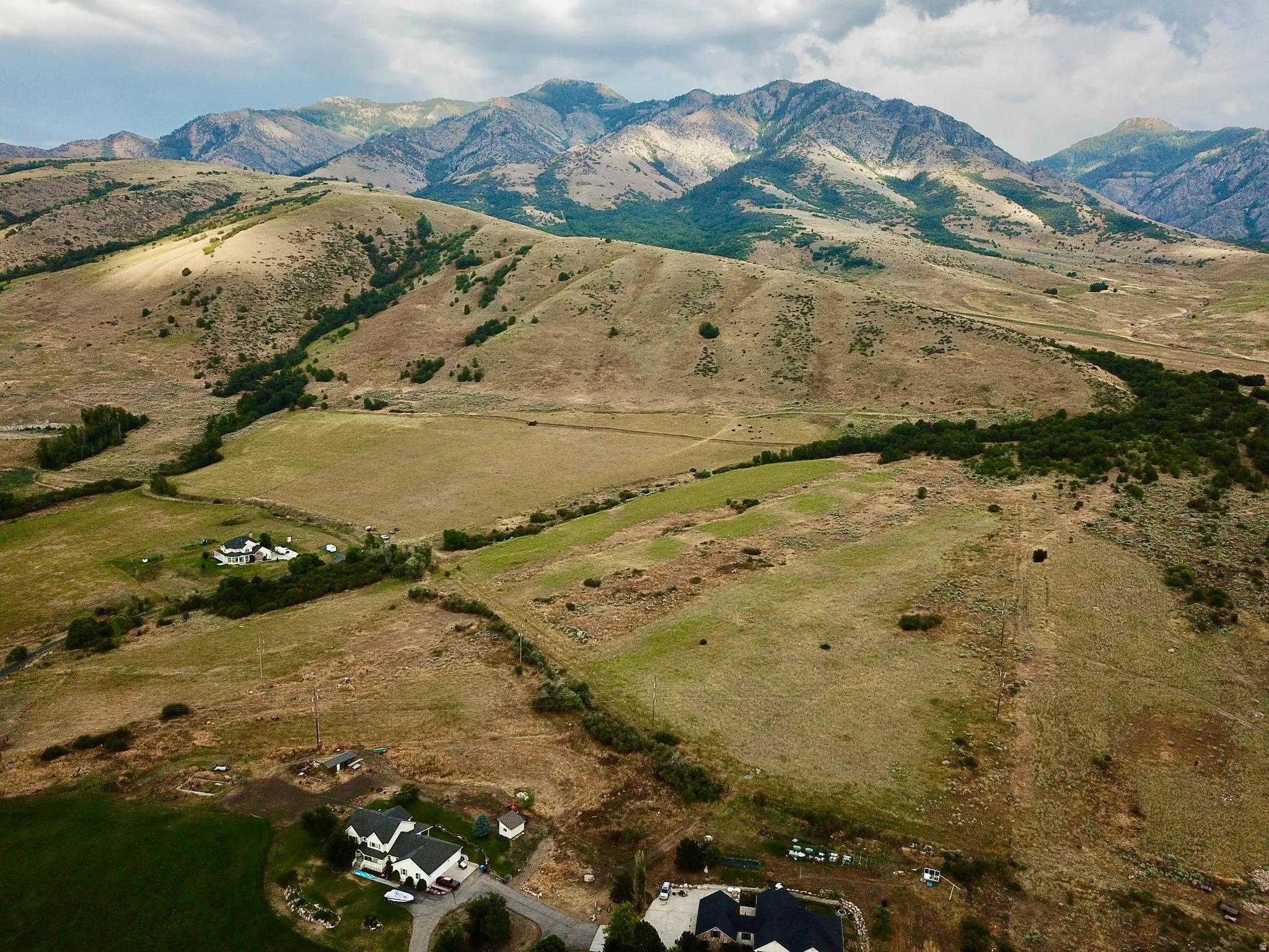 Expansive landscape featuring distant mountains and rolling hills with scattered greenery