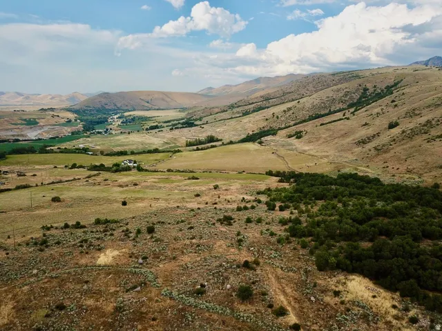Expansive natural landscape featuring rolling hills, varied terrain, and distant verdant valleys