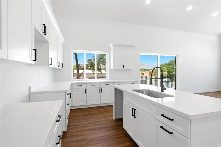 Modern kitchen featuring white shaker cabinetry with black hardware