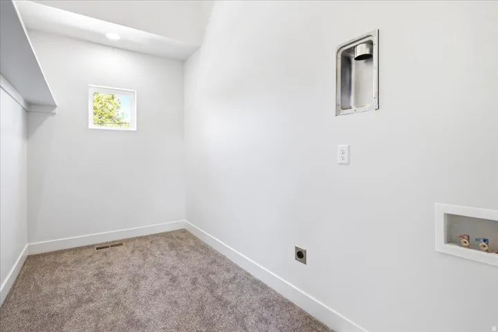 Dedicated laundry area featuring a square window, recessed lighting, and wall connections for appliances