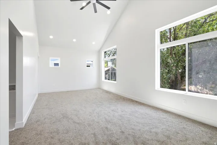 Vaulted ceiling with recessed lighting and a ceiling fan