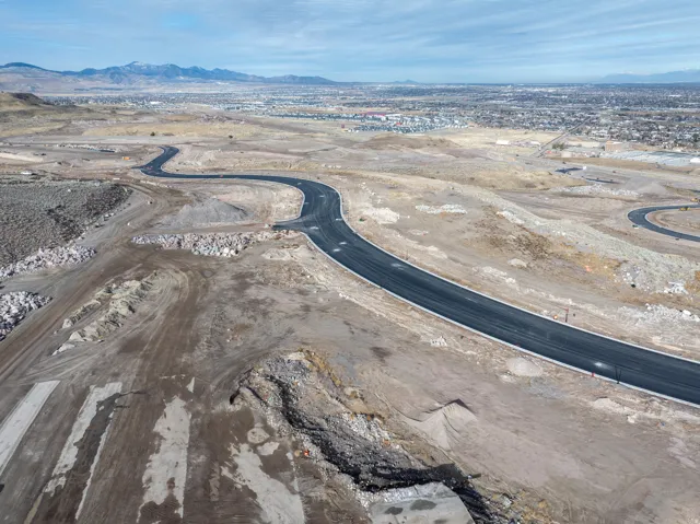 Developed land parcel featuring newly paved asphalt roads, visible streetlights, and graded terrain