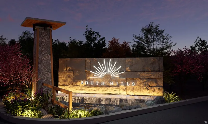 Illuminated stone entry monument featuring an integrated logo and property name