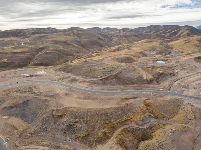 Expansive mountainous terrain with paved roads and graded areas