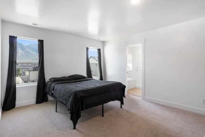 Expansive room featuring light-toned carpet flooring and white walls